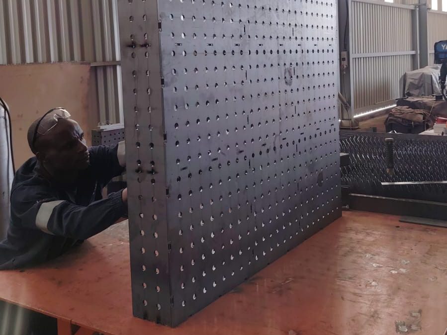 A welding table fabricated from nested plates, standing in the workshop